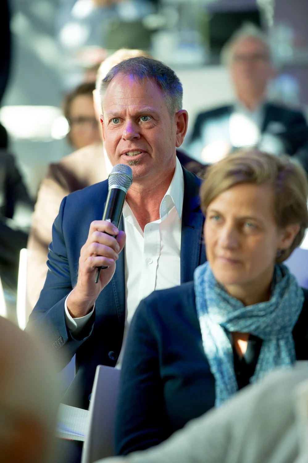 Wortmeldung aus dem Publikum während einer Diskussion – Tagungsfotografie mit lebendigen Momenten aus dem Saal.