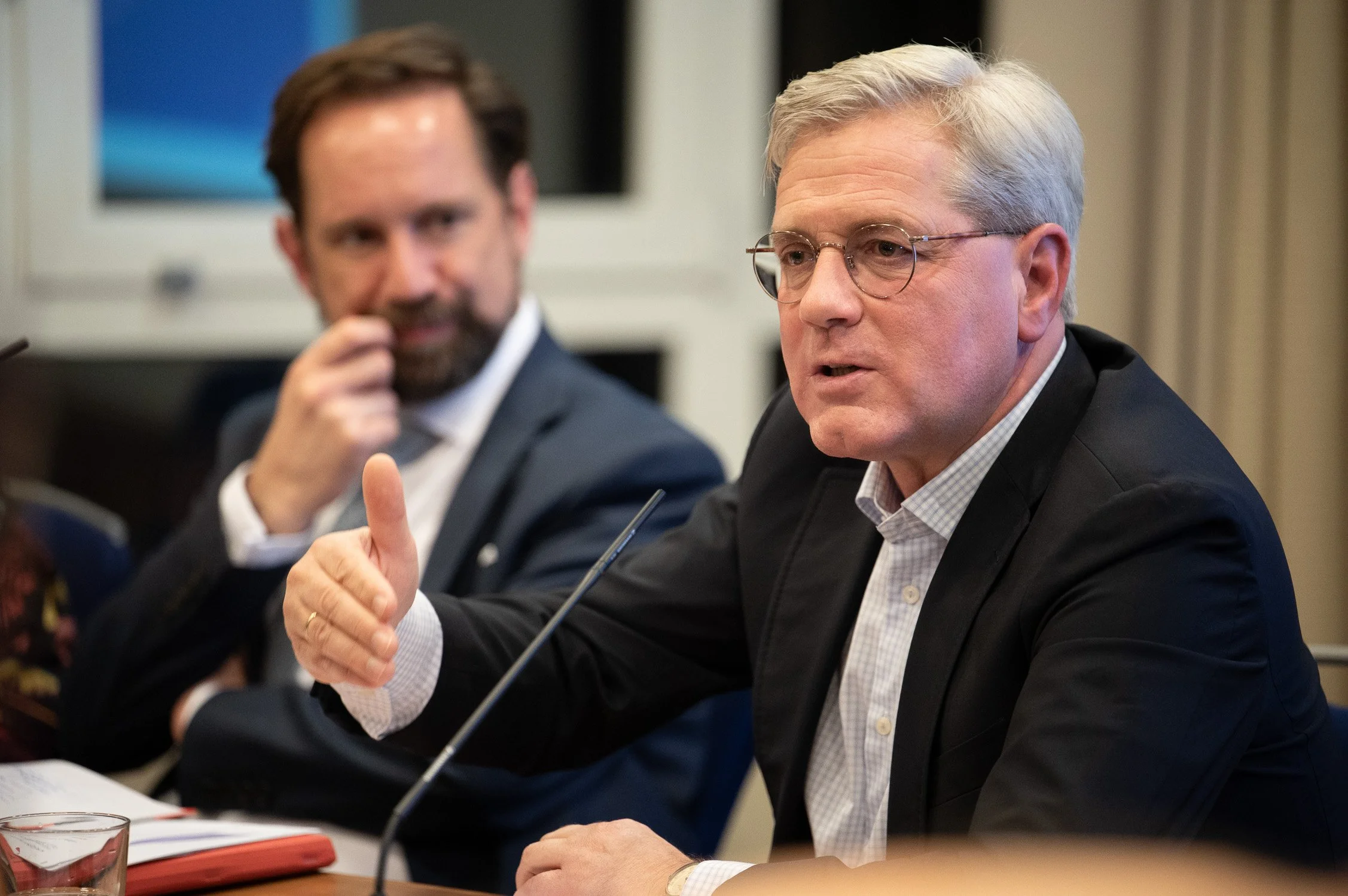 Norbert Röttgen im Gespräch an einem Tisch bei einer politischen Veranstaltung.