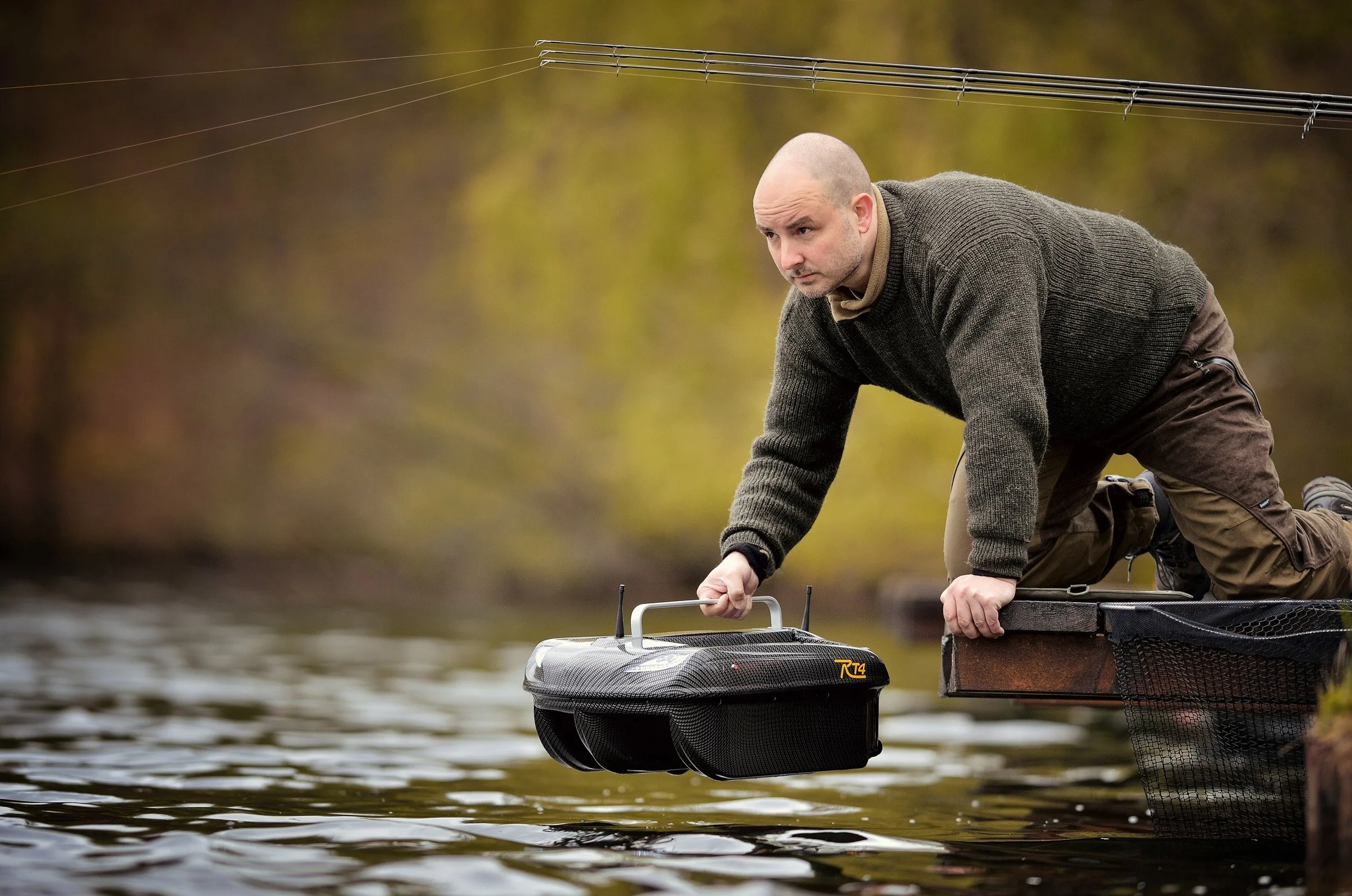 Mann setzt ein ferngesteuertes Futterboot auf einem See ein – Werbefotografie für einen Angelsport-Hersteller (Hennef)