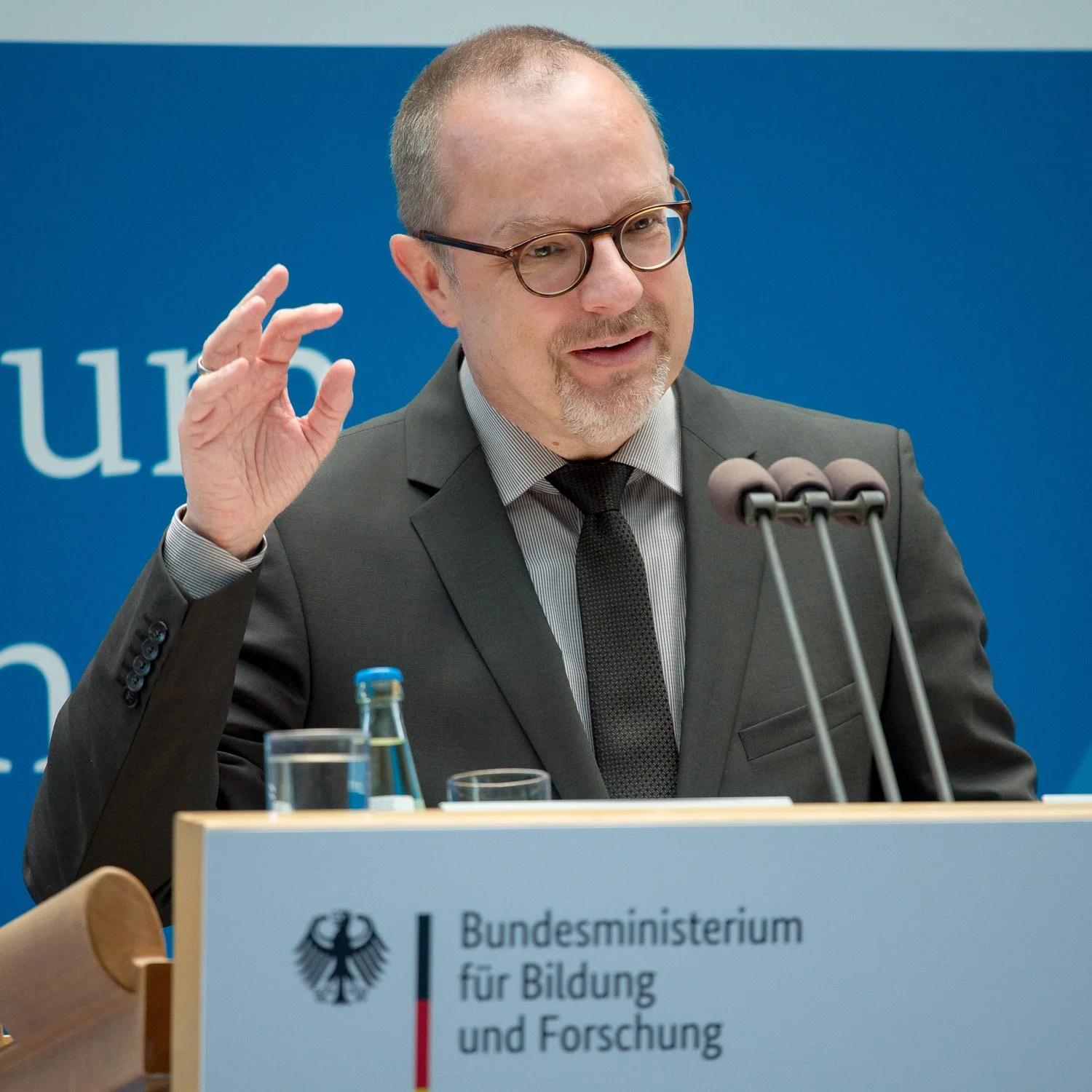 Redner am Podium des Bundesministeriums für Bildung und Forschung.