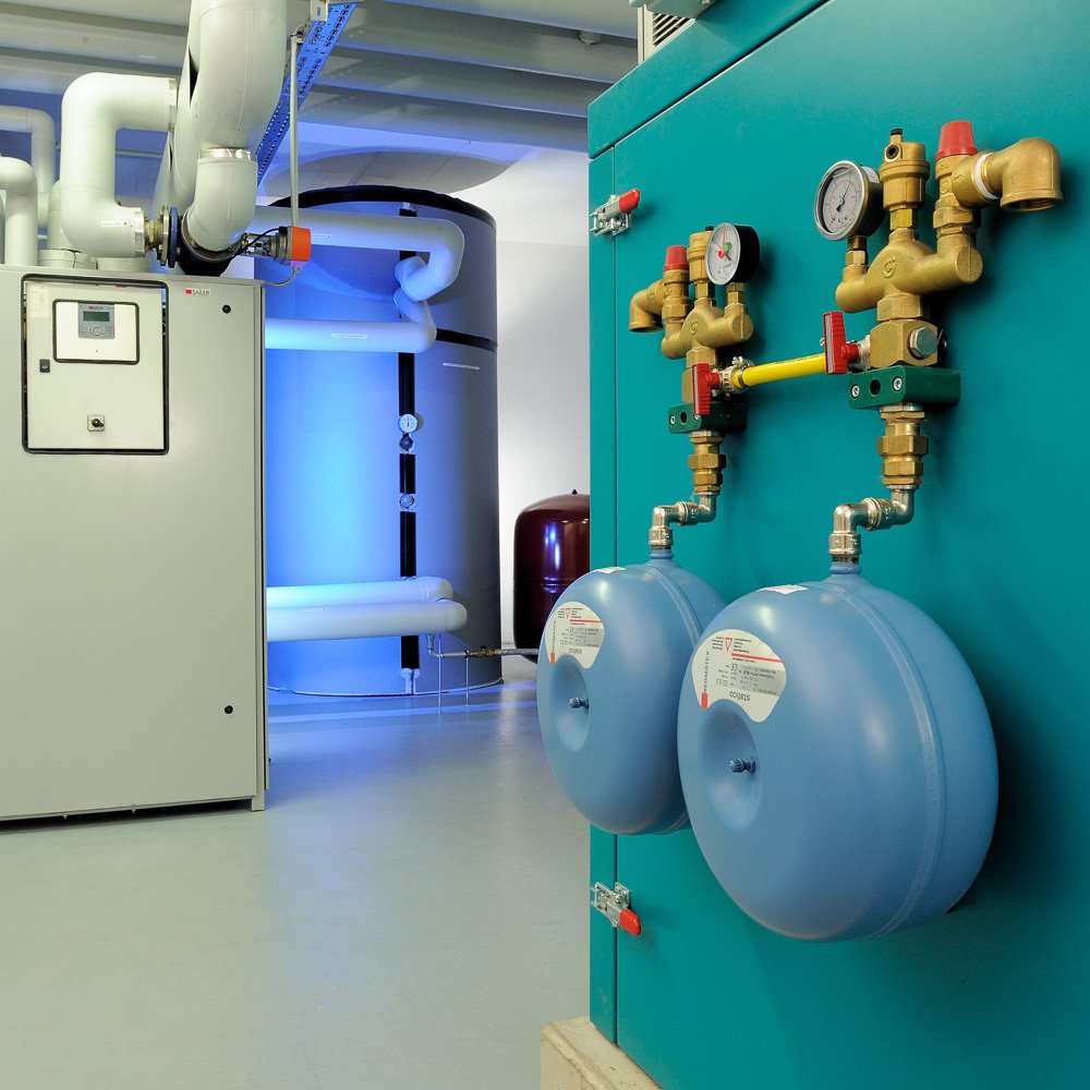 Technische Anlage mit blau beleuchteter Maschine und Messing-Armaturen – Industriefotografie