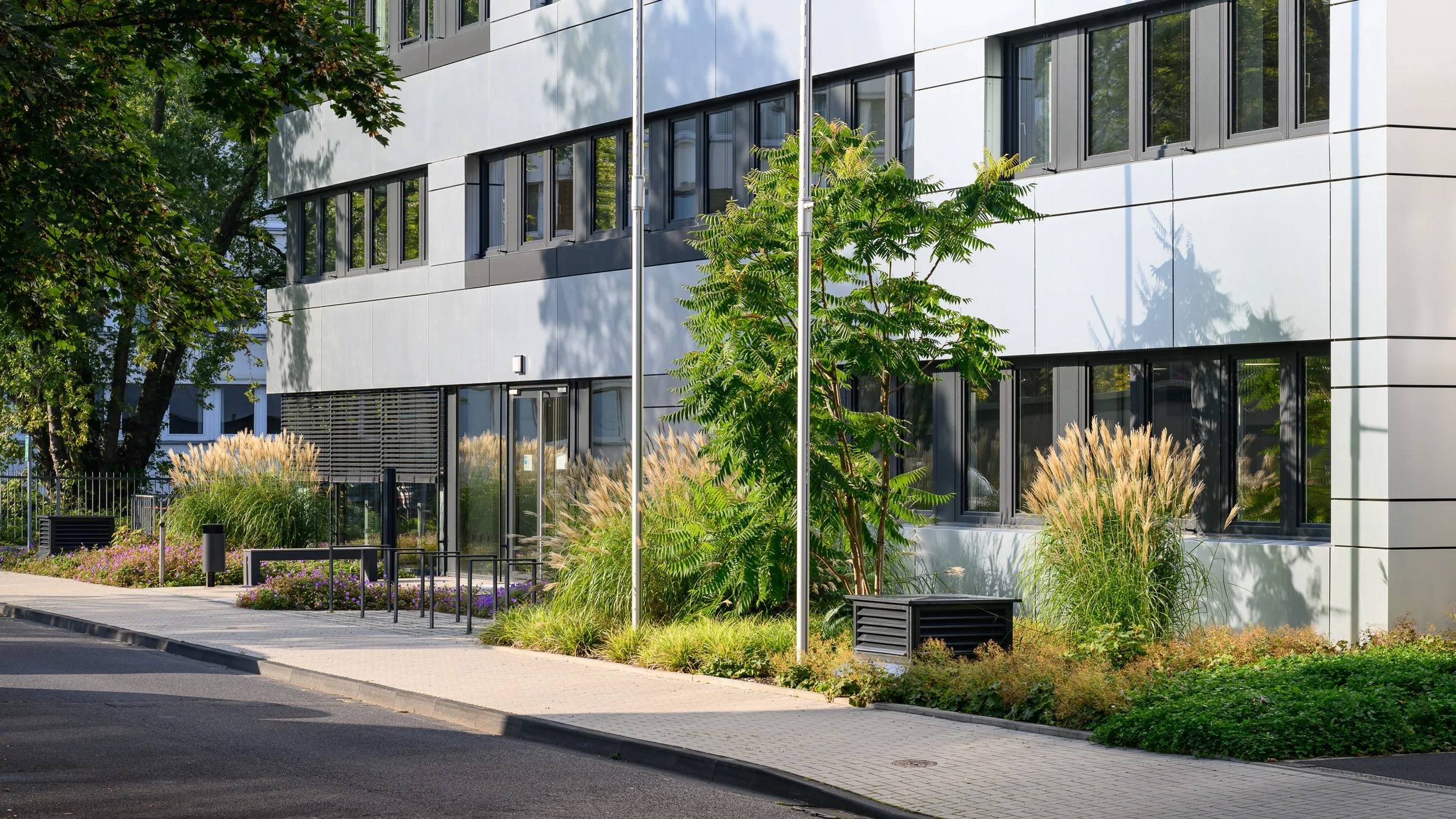 Modernes Bürogebäude mit heller Fassade und angelegtem Vorplatz – Architekturfotografie für Unternehmen in Köln und Bonn
