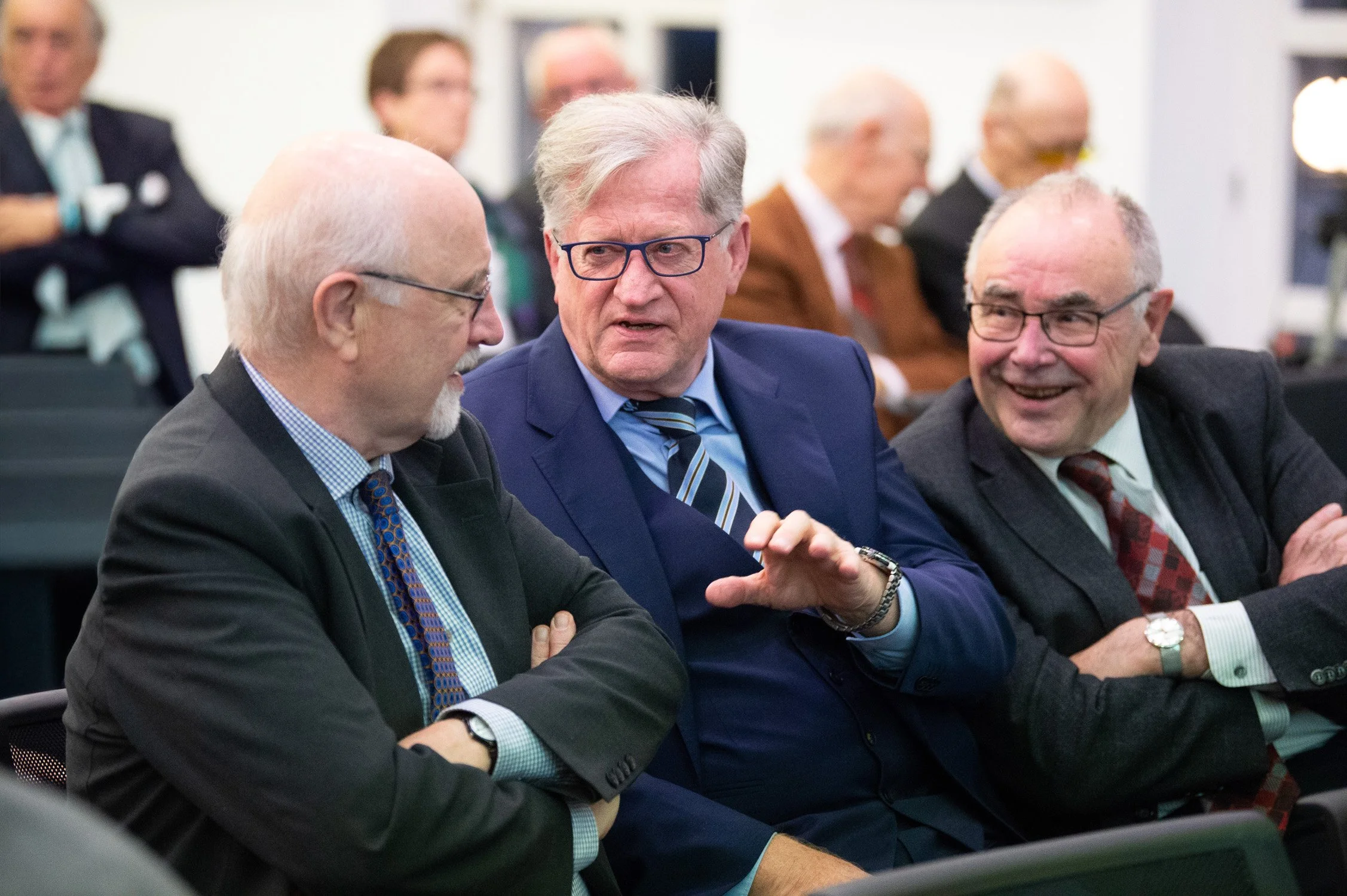 Drei Politiker im Gespräch bei einer Veranstaltung.