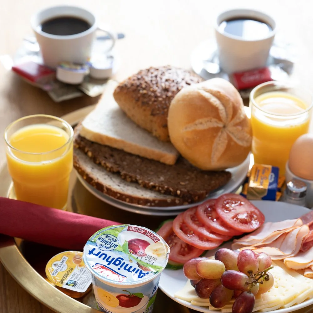 Reichhaltig gedeckter Frühstücksteller mit Kaffee und Saft – Hotelfotografie in Königswinter.