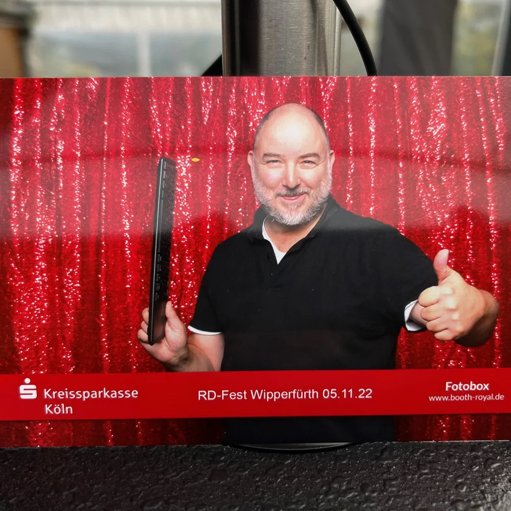 Gast hält einen frischen Papierabzug aus der Fotobox in der Hand