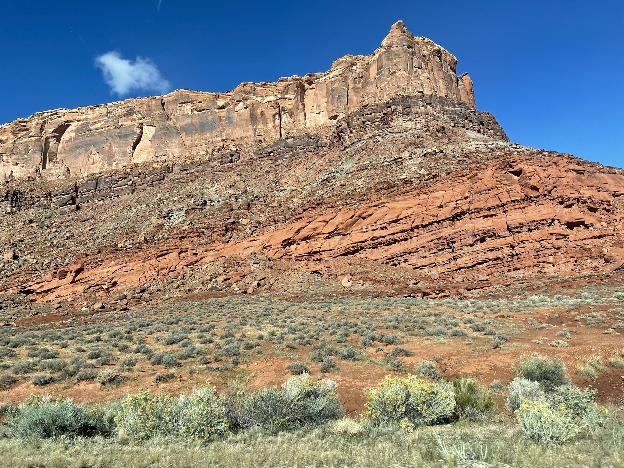 Layered red and cream sedimentary rock face near Moab, Utah