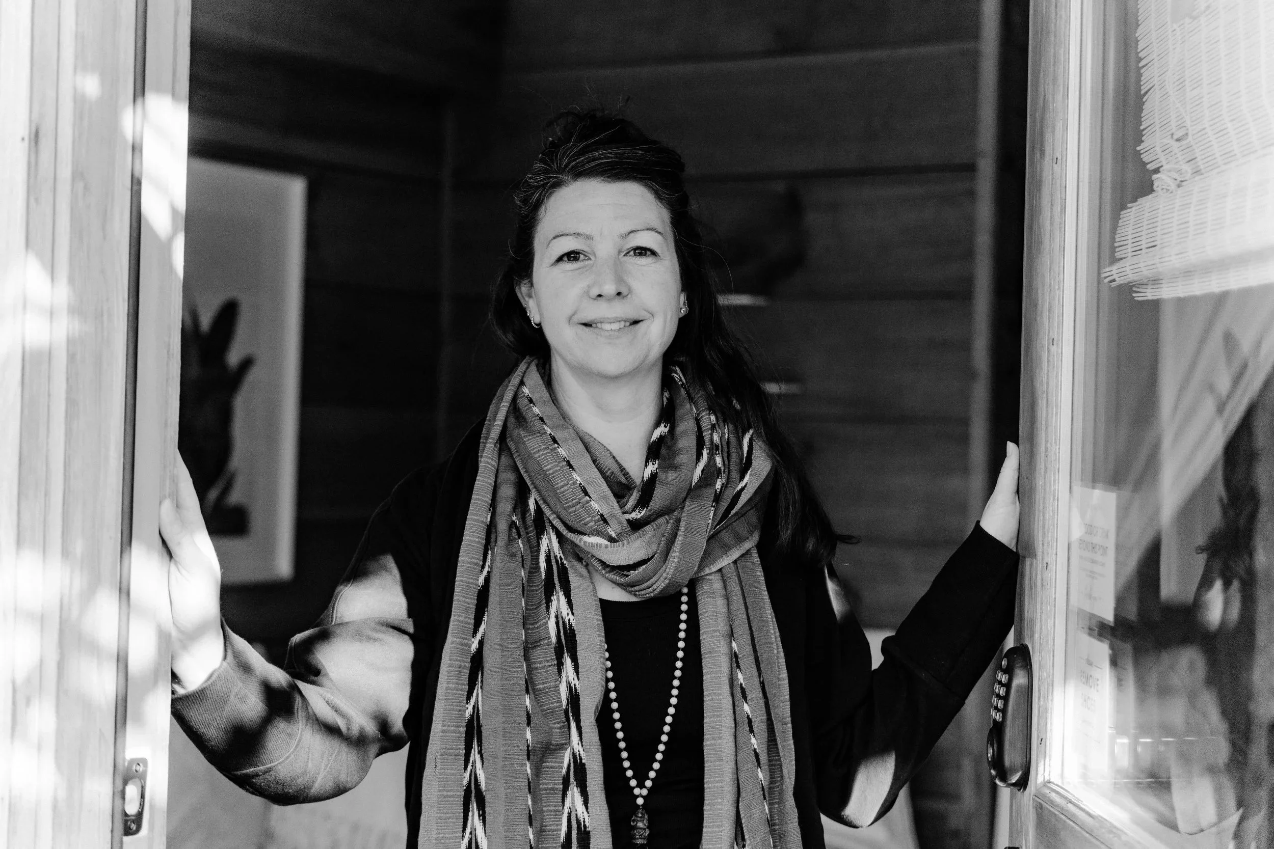Erin opening the door to invite a client in for a craniosacral therapy healing session