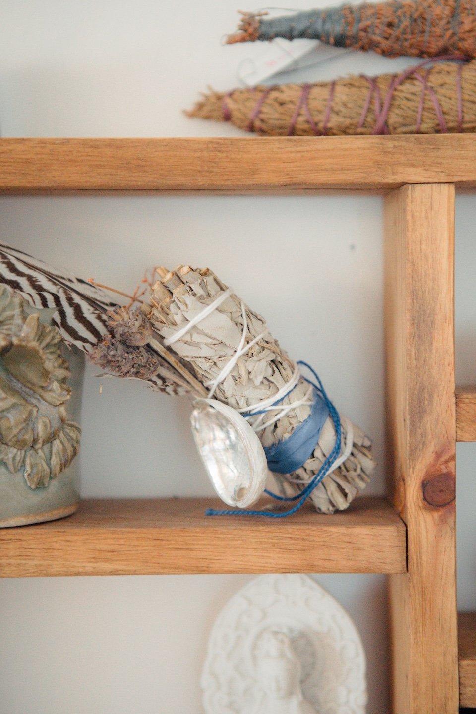 Decorative driftwood and shell arrangement on a wooden shelf.