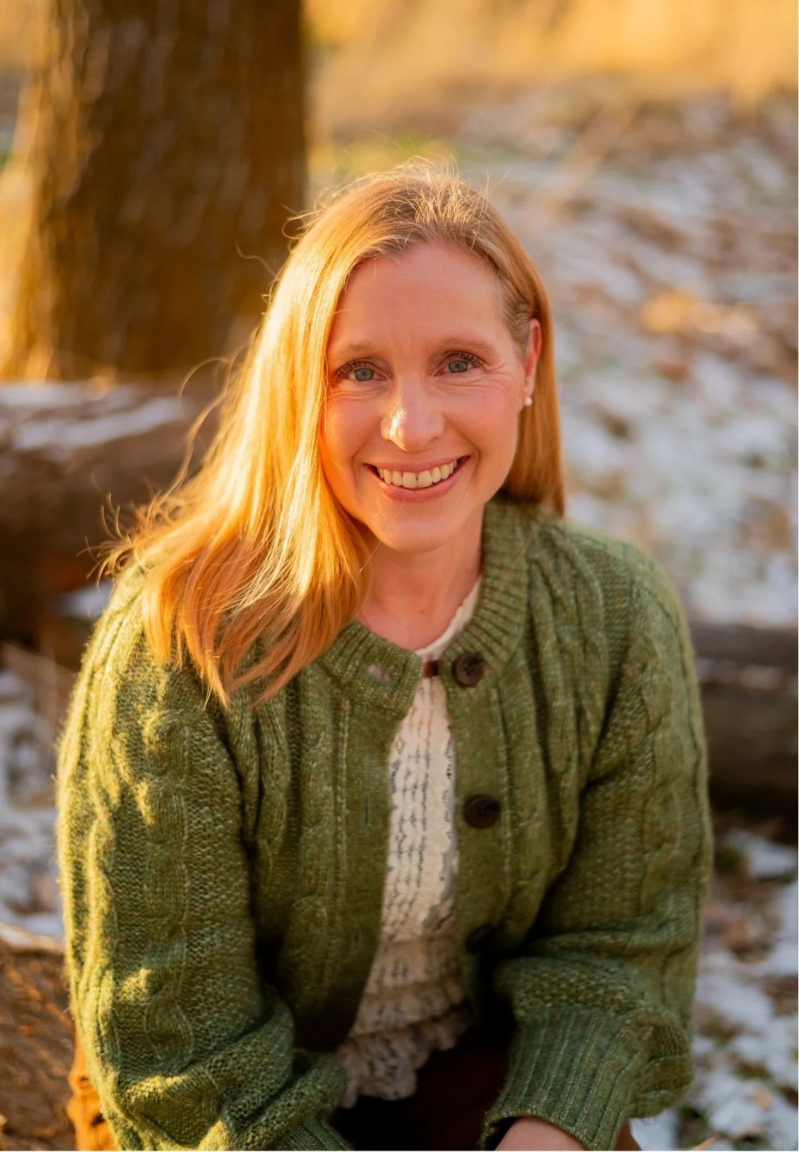 Kristina Robbins, therapist in Spanish Fork, smiling warmly, wearing a green knitted sweater and a cream-colored knit top.