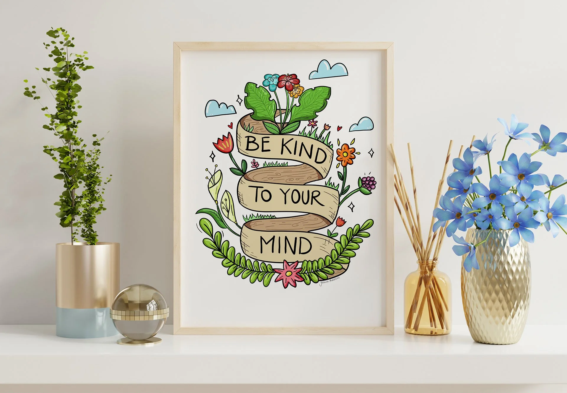 Decorative framed art with a motivational quote, surrounded by plants and flowers on a white surface.