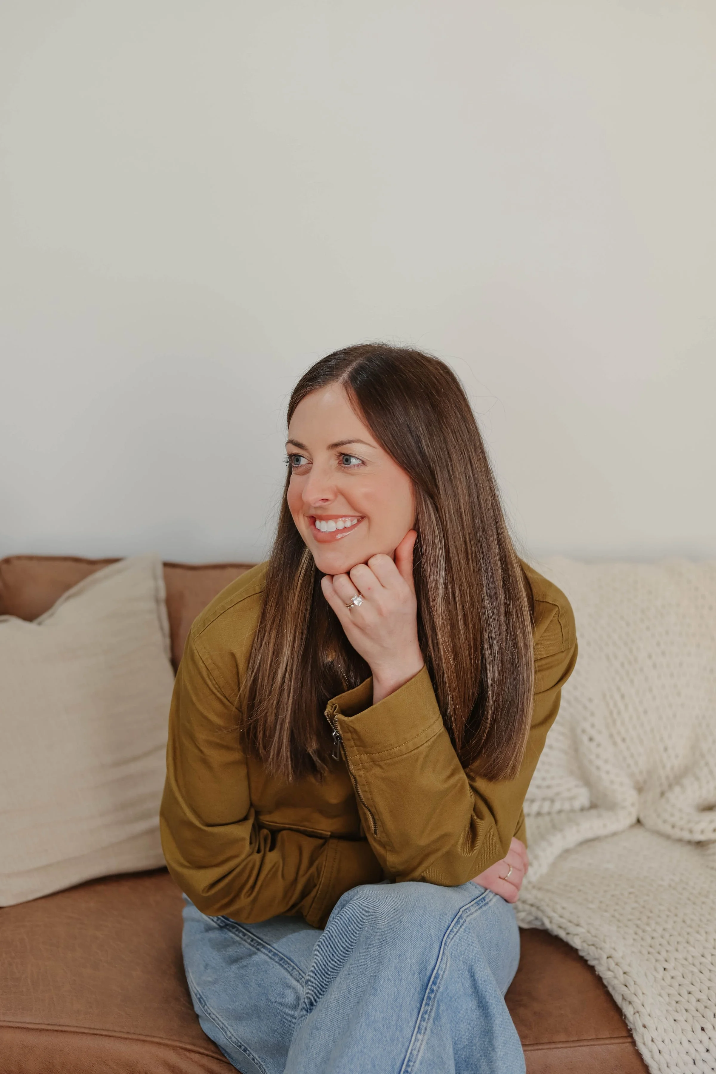 Josie Ball, LCSW, Therapist in Nashville TN | Josie smiling and looking to the side, sitting on a couch