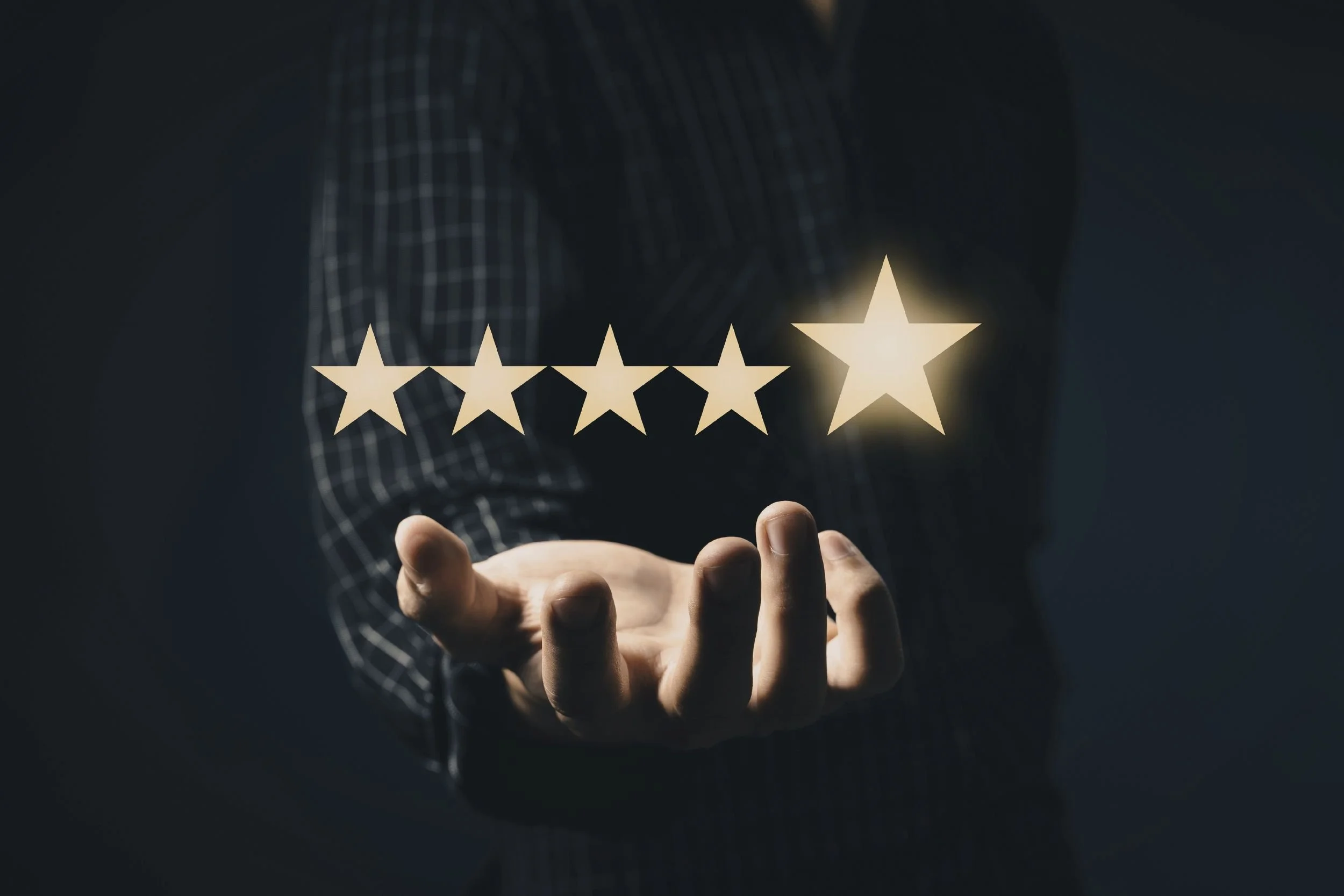 An outstretched hand against a dark background with a glowing five-star rating floating above the palm.