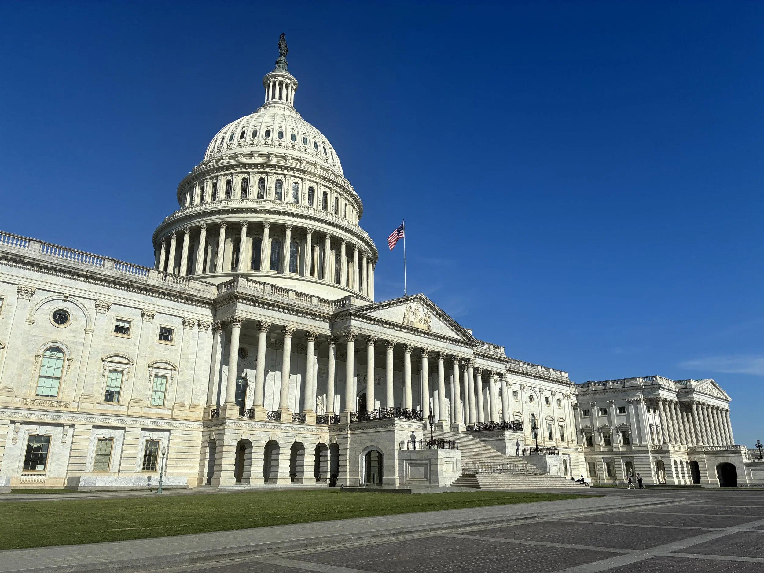 The United States Capitol building against a bright blue sky, representing the Washington D.C. curated restaurant and dining guide.