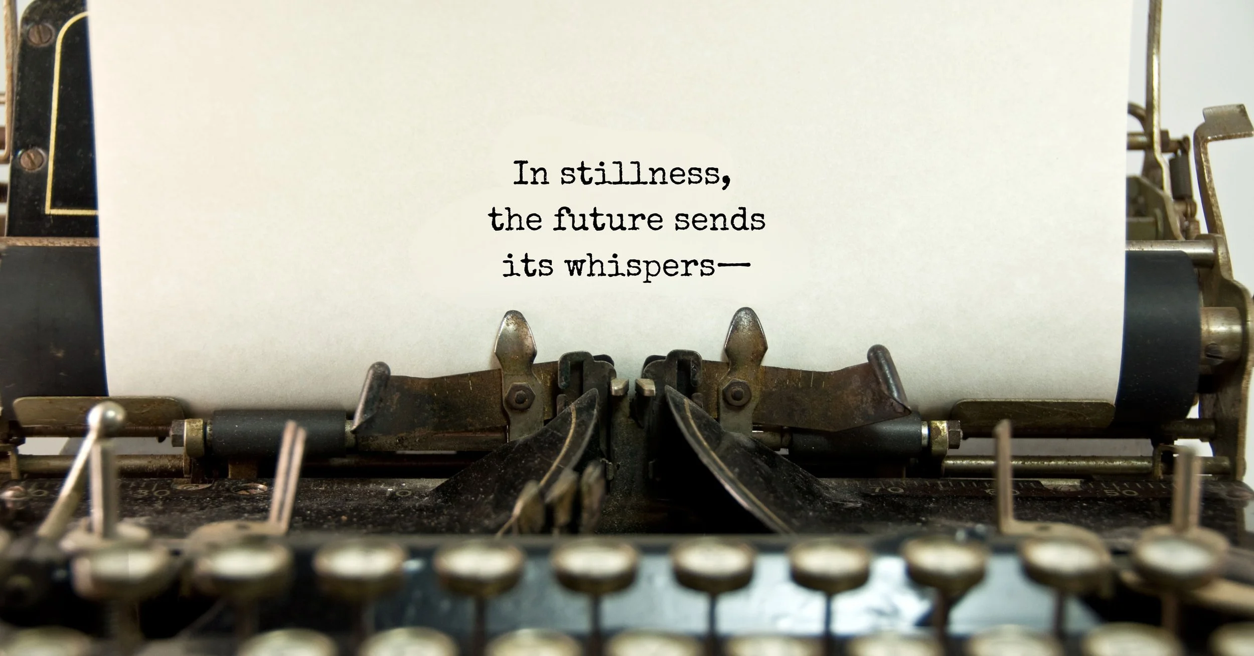 Close-up of a vintage typewriter printing a piece of paper with the quote, 'In stillness, the future sends its whispers—'.