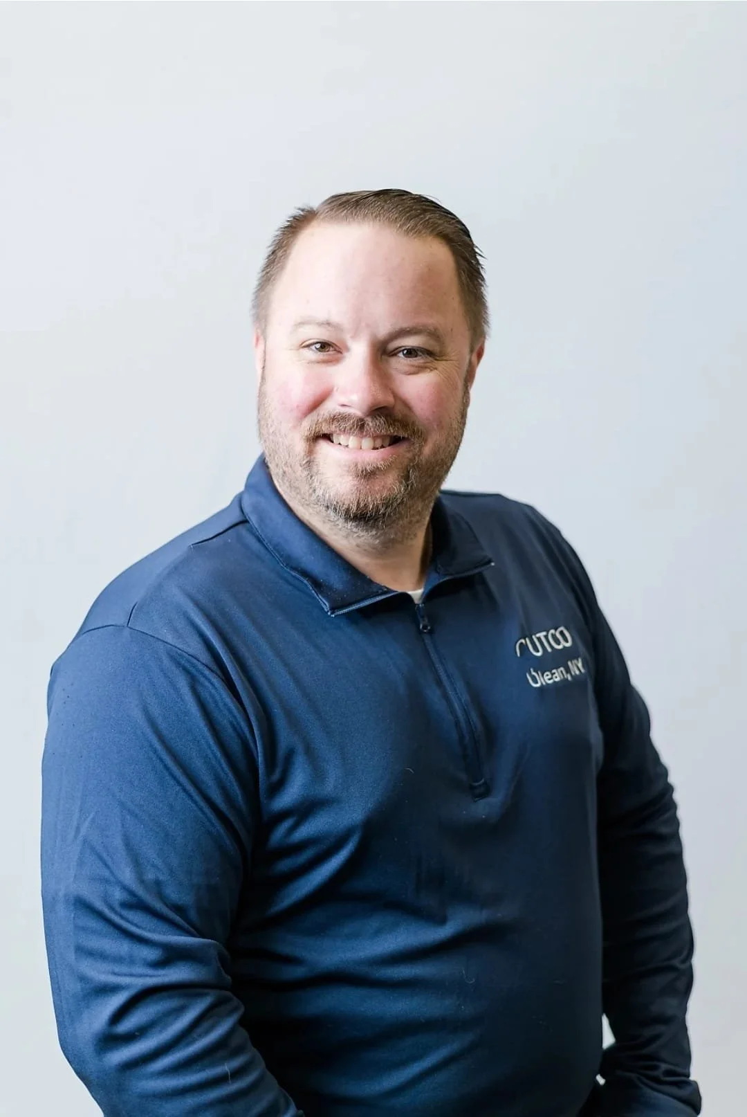 smiling man with brown hair and blue shirt