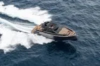 A motorboat speeding across the ocean, creating a wake behind it.