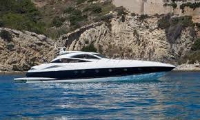 Luxury Sunreef predator 82  cruising on blue water near rocky cliffs.