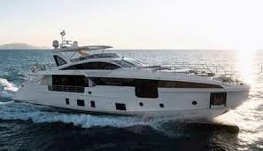 A large white yacht sailing on the ocean with a clear sky.