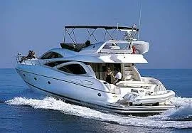 A white yacht sailing on the water with a clear blue sky in the background.