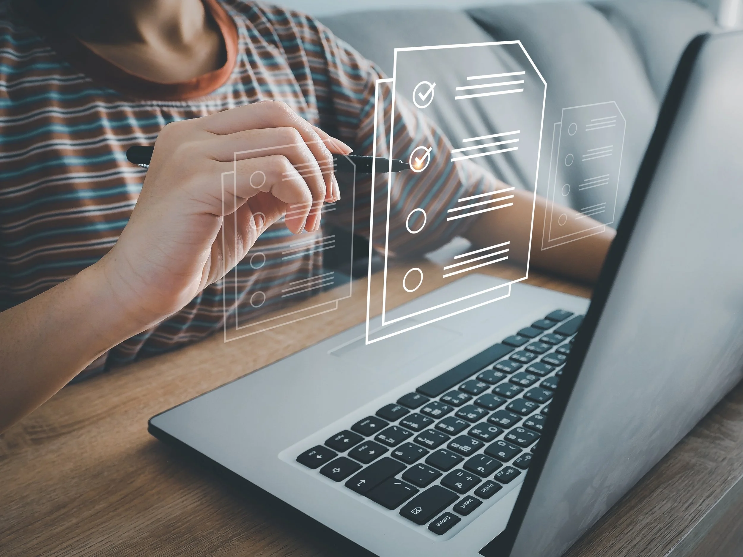 Person in a striped shirt interacting with a digital interface of checklists and documents on a laptop.