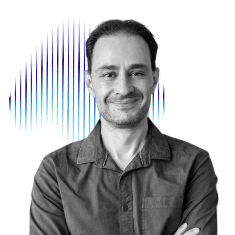 Black and white photo of a smiling man with dark hair, wearing a button-up shirt, standing in front of an abstract blue and green digital graph or data visualization.