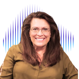 A smiling woman with long brown hair and glasses, wearing a brown top.