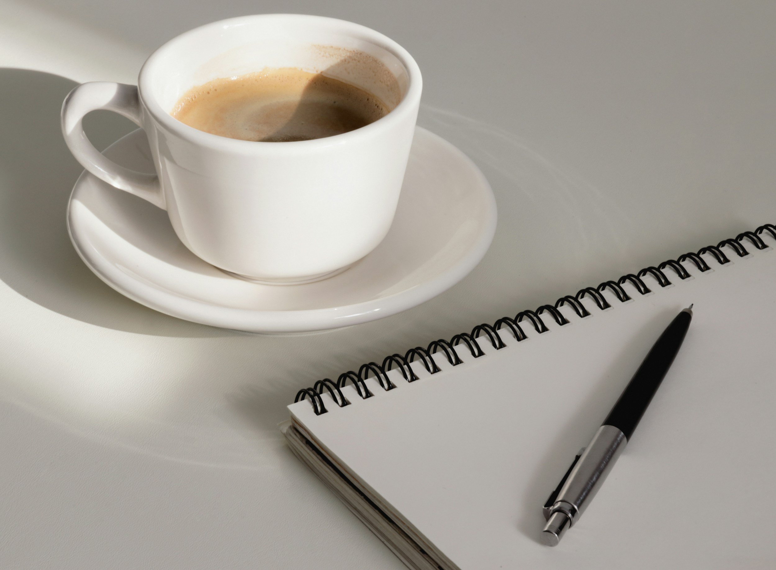 coffee cup with notebook and pen