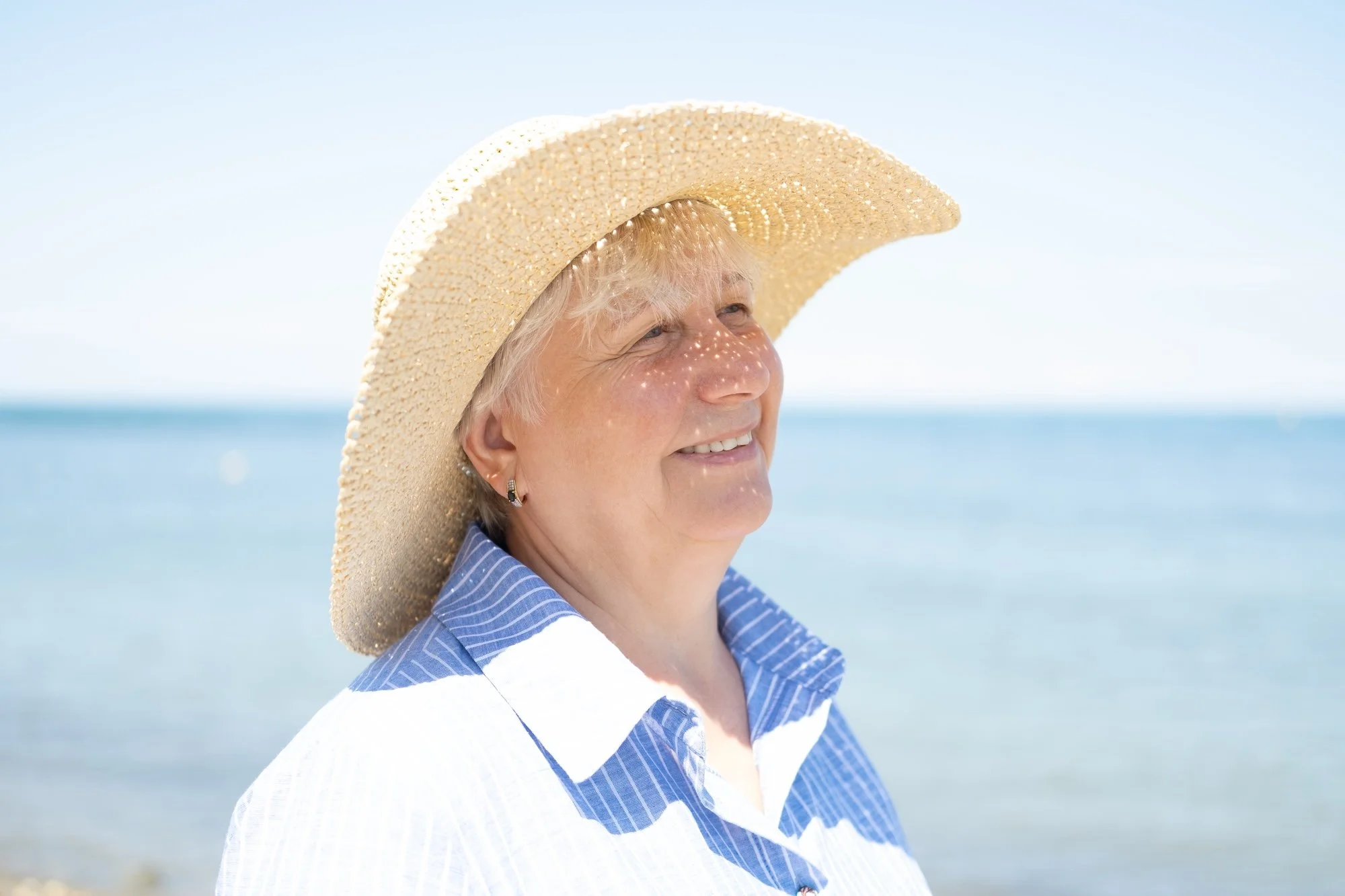Mature woman wearing a wide brimmed hat to protect herself from sun exposure