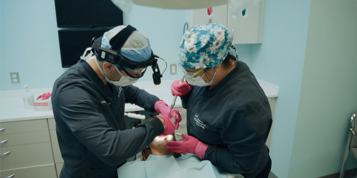 Oral surgeons perform a procedure on a patient at the Center for Oral Surgery + Dental Implants