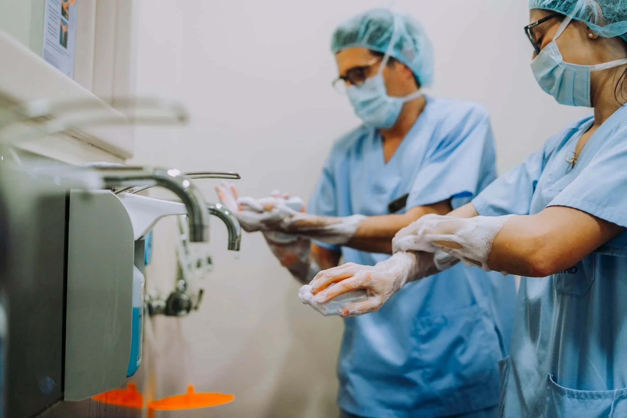 Oral surgeons washing hands before surgery.