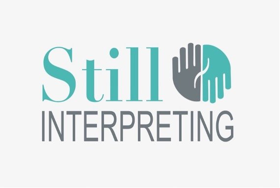 Logo with the words 'Still Interpreting' and an icon of two hands, one gray and one teal, touching palms.