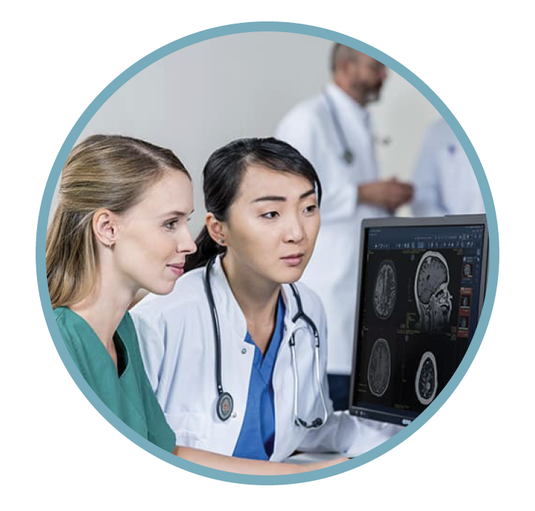 Medical professionals reviewing brain scan images on a computer in a hospital setting.