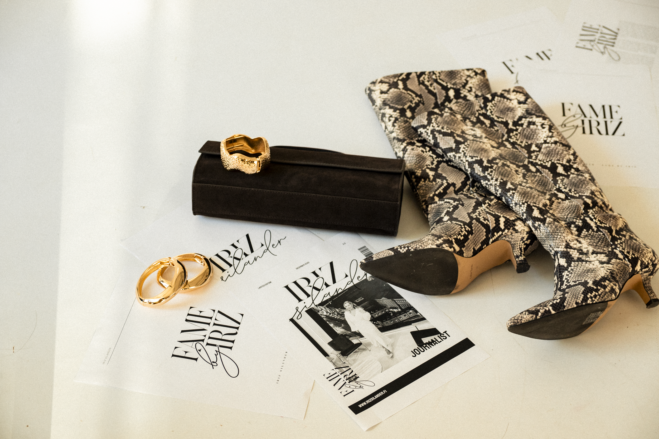 Muoti- ja lifestyle-aiheinen asettelukuva asusteista ja aikakauslehdistä.