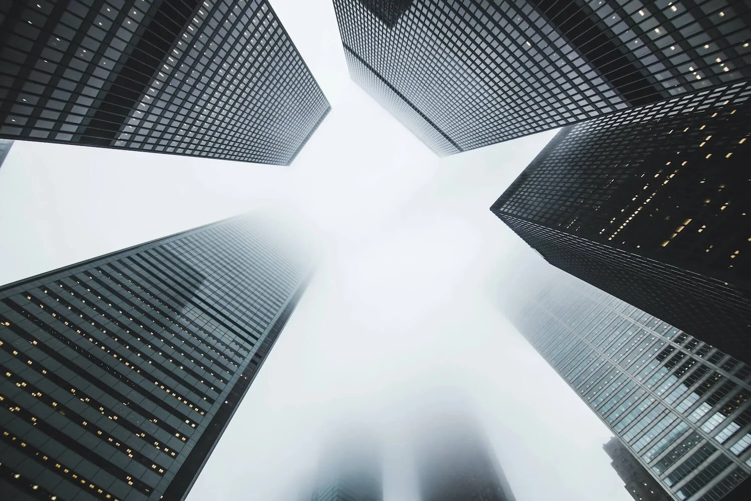 Looking up at tall corporate office buildings representing the high-pressure Big Law attorney career and workplace stress