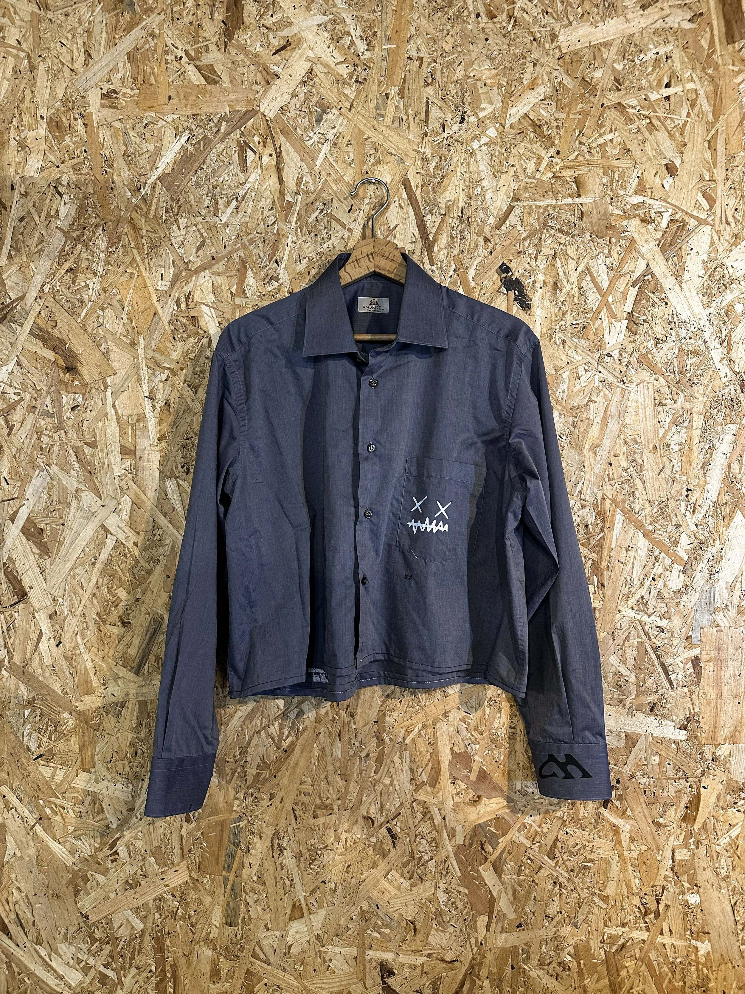 Front di una camicia con grafica BASURA.