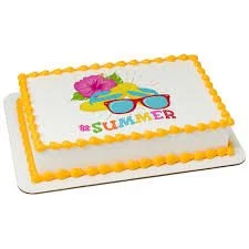 A rectangular summer-themed cake with yellow icing border, decorated with sunglasses, flowers, and the word 'SUMMER' in colorful letters.