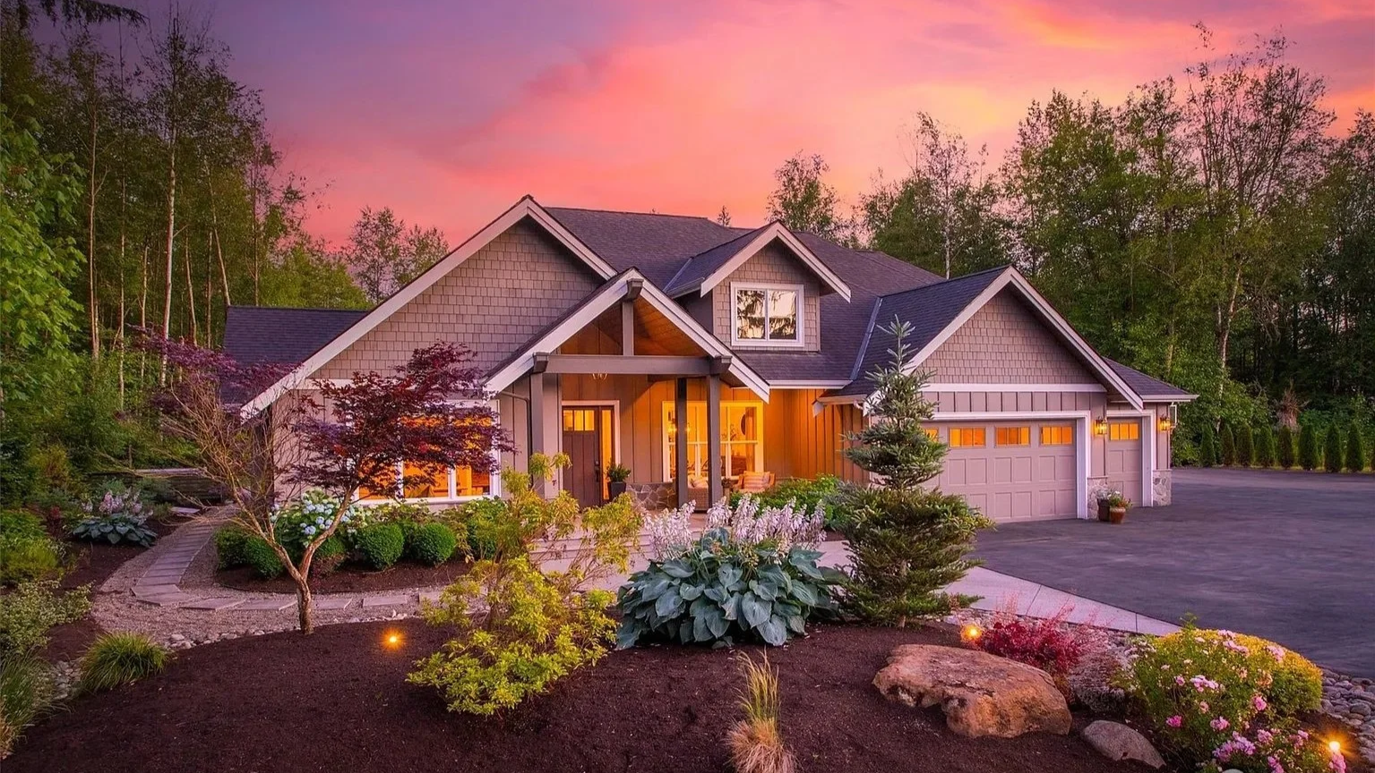 High-performance custom home in Arlington, WA by Agnew Homes Northwest, featuring a timber-frame entryway, custom stonework, and energy-efficient design at dusk.