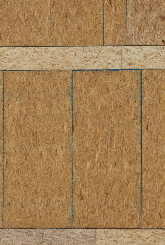 Standard plywood wall sheathing with visible air gaps, showing a lack of airtight sealing in traditional construction.