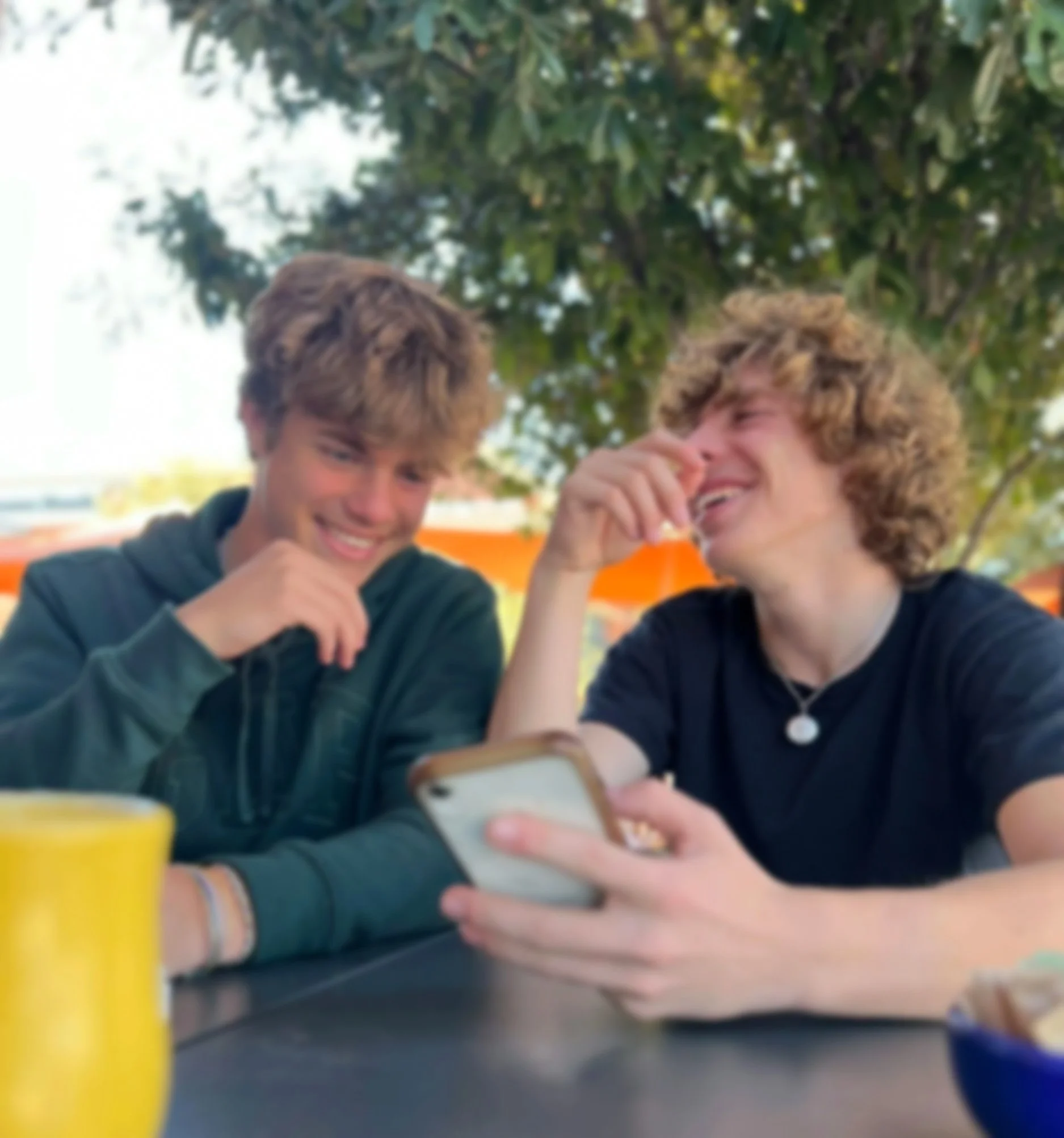 Christian teenagers laughing together at a picnic table.
