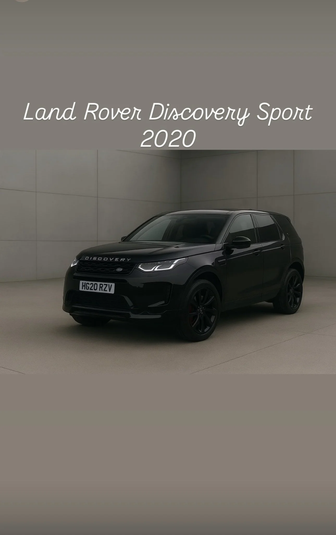 A black Land Rover Discovery Sport 2020 vehicle displayed in a concrete-walled showroom.