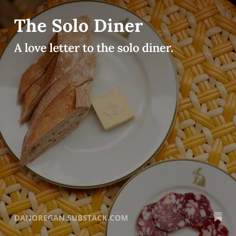 A plate of baguette slices with a pat of butter on a decorative dinner plate, placed on a woven placemat.