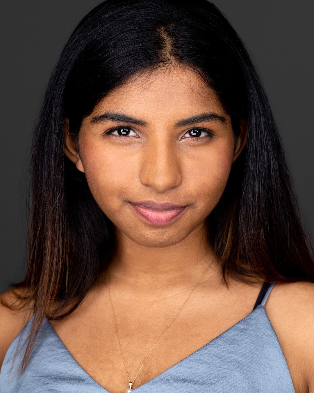 Acting headshot of a woman wearing blue top