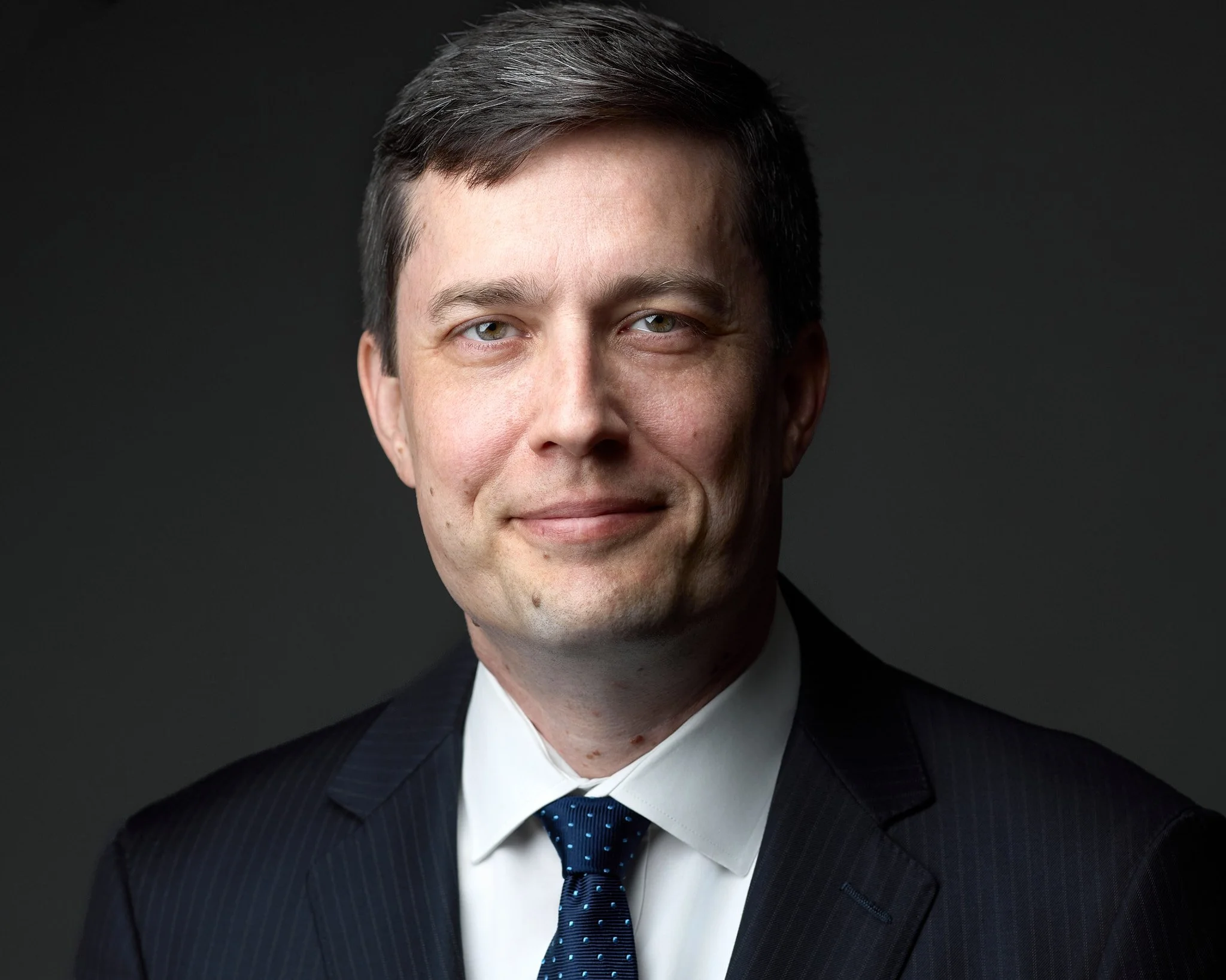 Professional Headshot of an executive in a suite with a blue tie