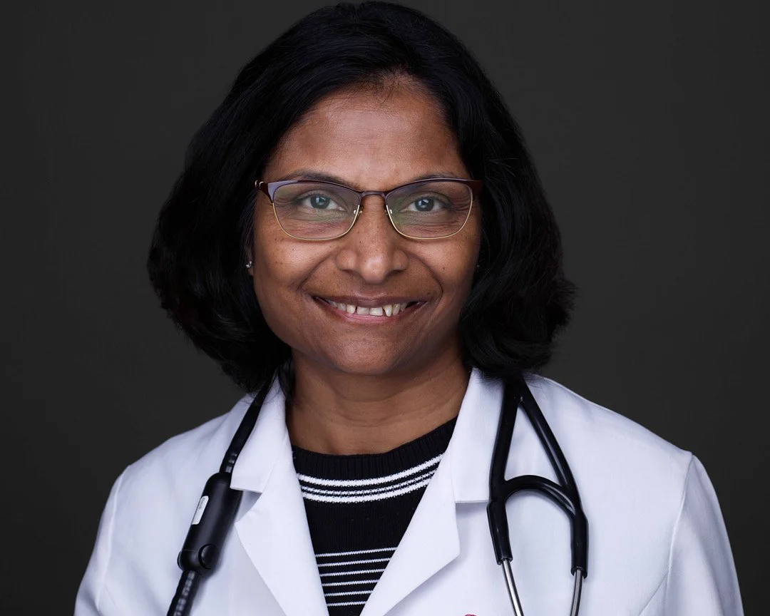Professional Headshot of a female doctor wearing white coat with a stethoscope around her neck