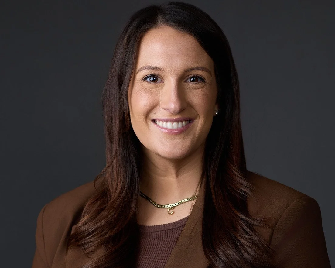 Headshot of a female executive wearing a brown shirt and blazer