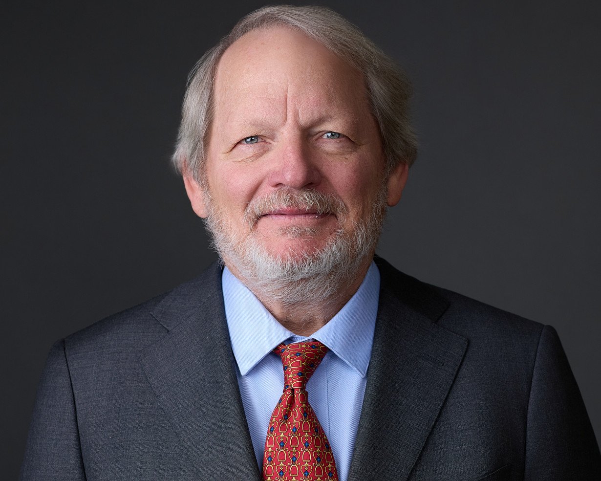 Headshots of an older man wearing a suit and tie