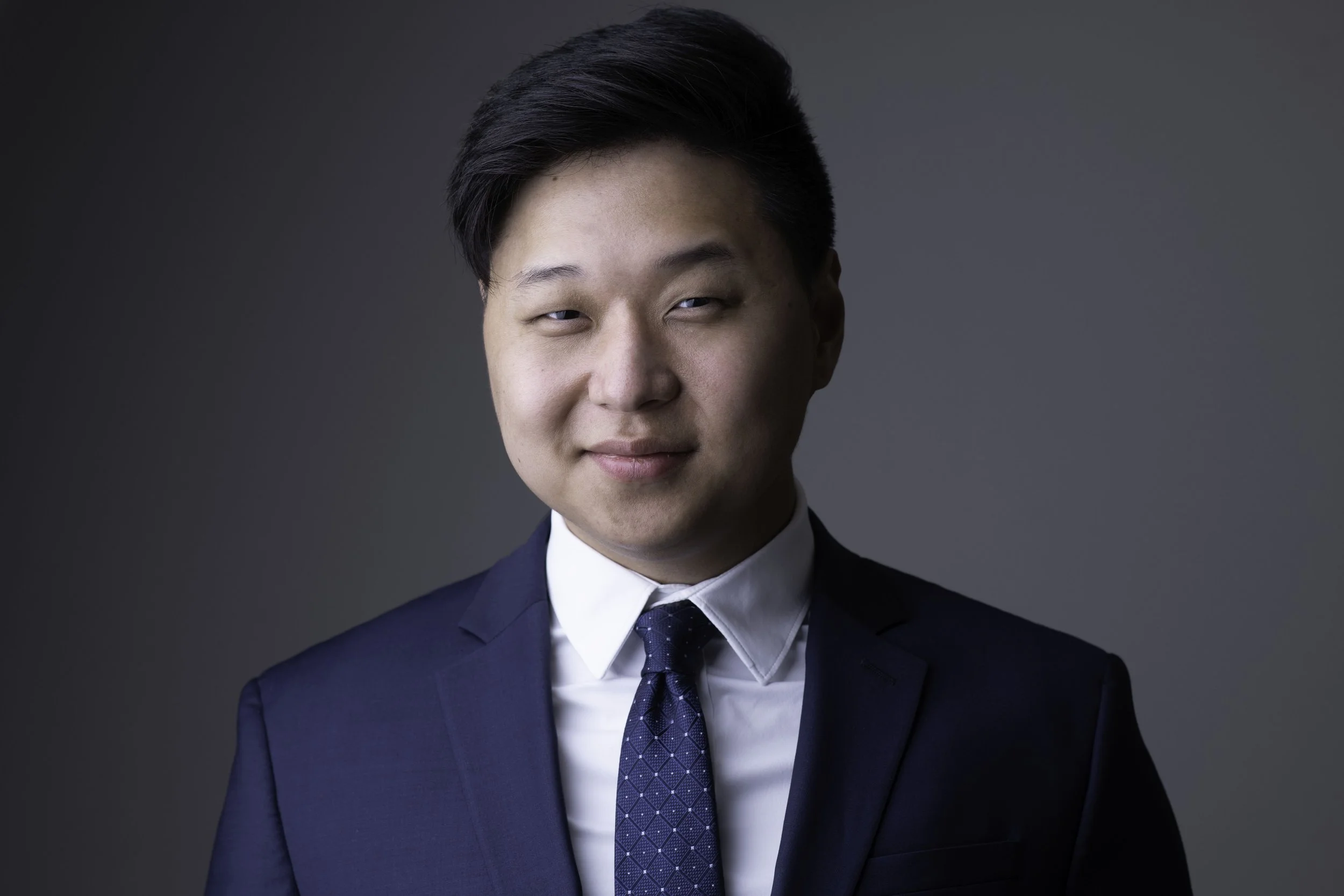 business headshot of a man in a blue suit and tie