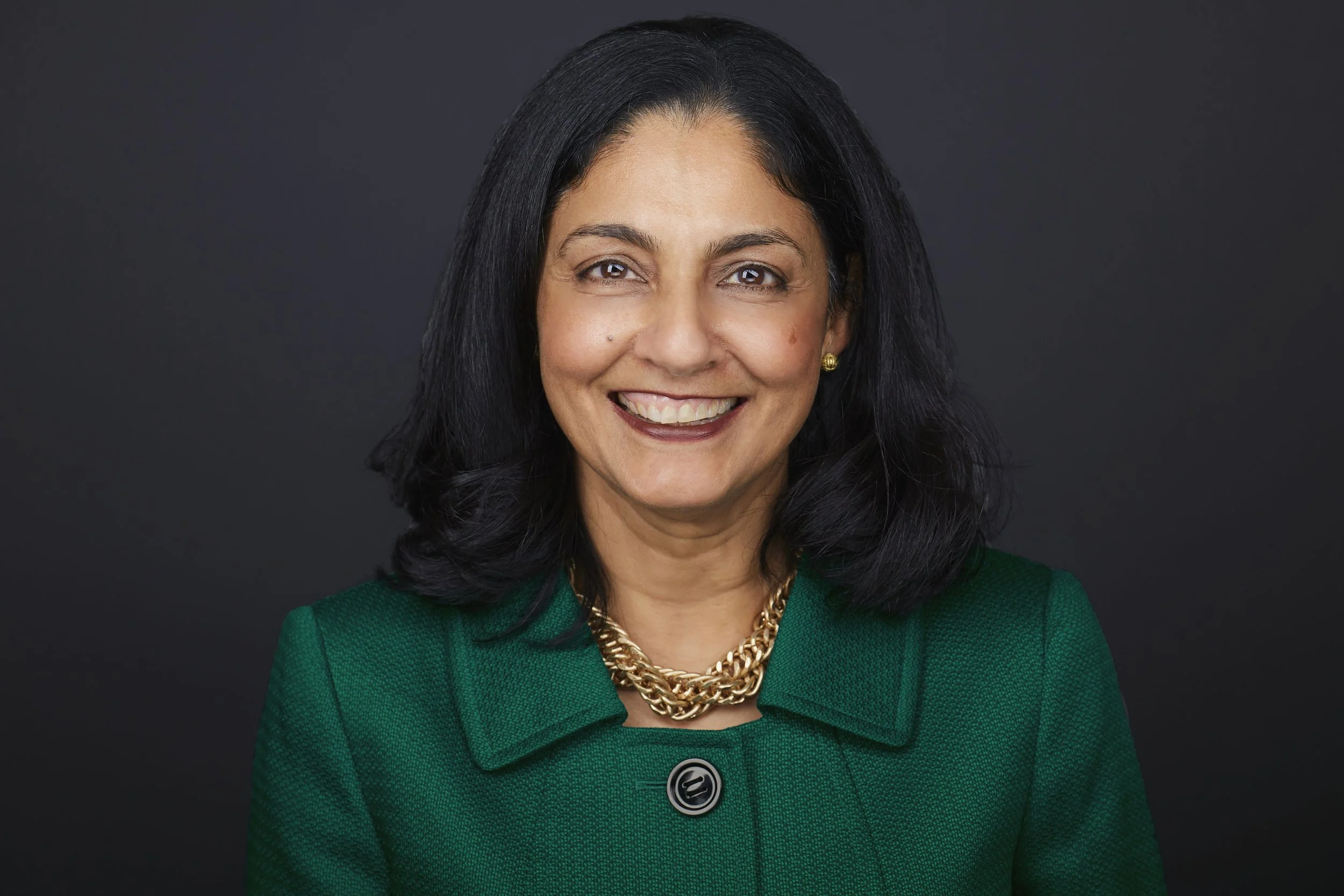 Doctor headshot of a woman wearing a green jacket