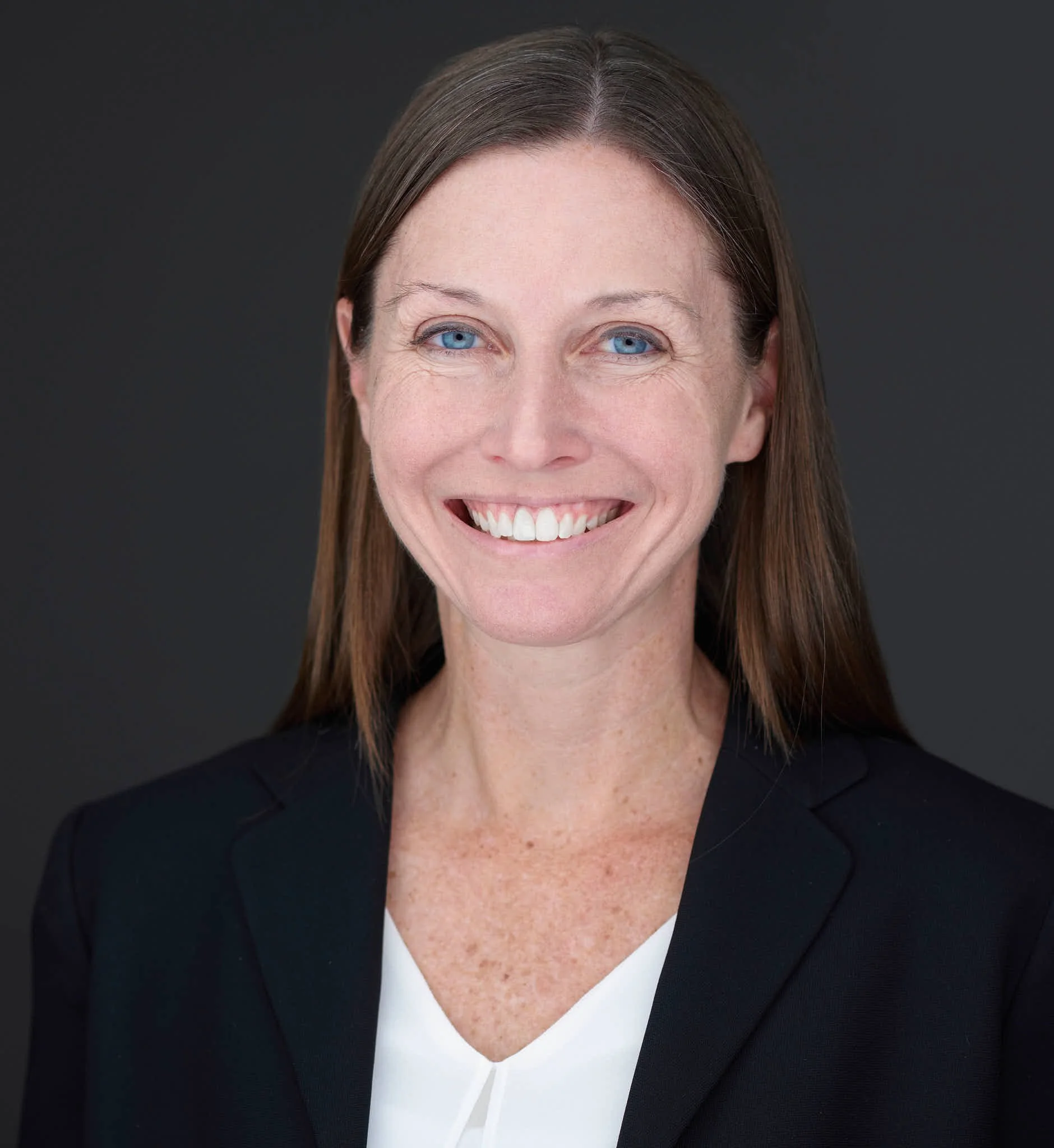 Headshot of a woman wearing a white blouse and black blazer