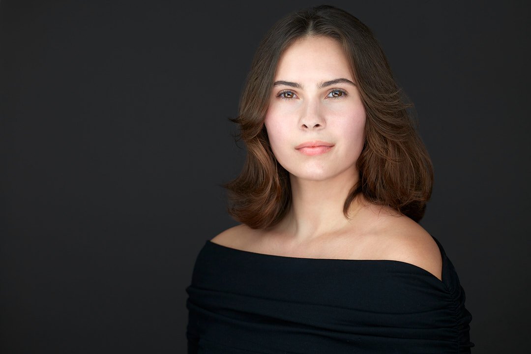 Headshot of a brunette woman wearing a black top